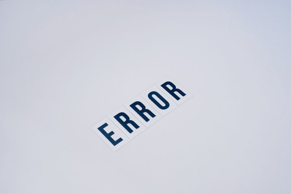 A close-up image of a white background with the word 'ERROR' printed in bold, dark blue capital letters on individual white rectangular tiles arranged diagonally. The tiles have a smooth, matte finish and are evenly spaced, creating a clear visual focus on the error message. The lighting is soft and even, with no shadows or reflections visible, emphasizing the minimalistic and neutral presentation. This image relates to troubleshooting or addressing issues in online booking or service systems, such as those encountered by rubbish removal providers like Rubbish Removal Hackney, highlighting the importance of resolving technical errors in private waste disposal or independent collection services.